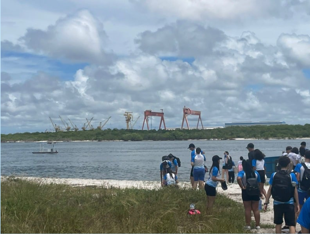 Foto da equipe de pesquisa realizando a coleta de água no ponto C, localizado em uma área de praia.